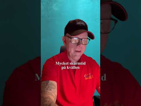Clip-on blåljusfilter monterat på glasögon vid kvällsarbete framför dator och mobil för behagligare skärmanvändning.